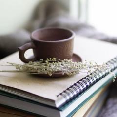 Stack of books and journals with a cup of tea